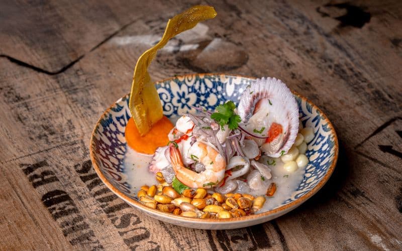 Plato de ceviche servido en una mesa de madera